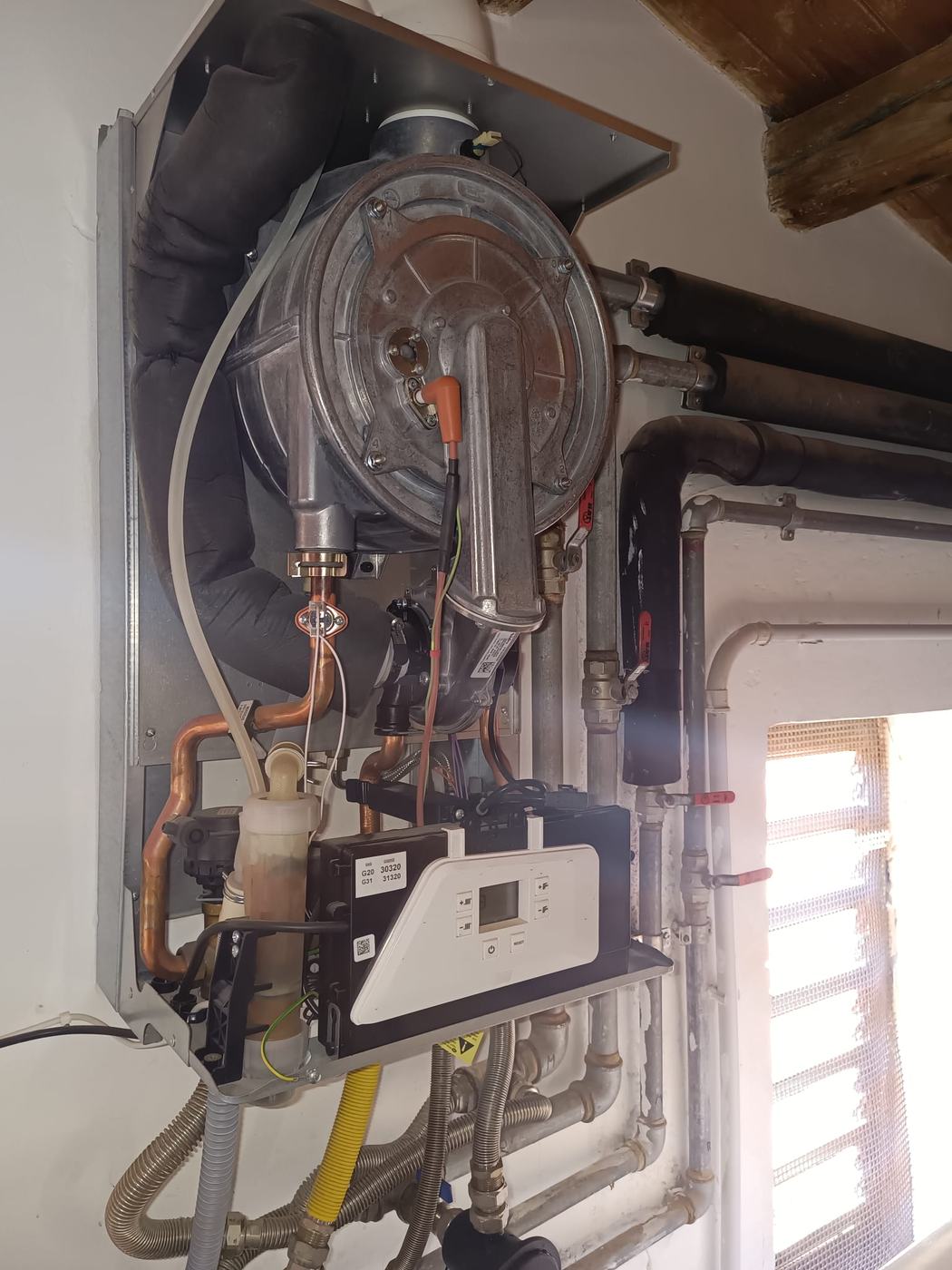 Manutenzione di una caldaia a condensazione con scambiatore, ventilatore e valvola gas a vista
